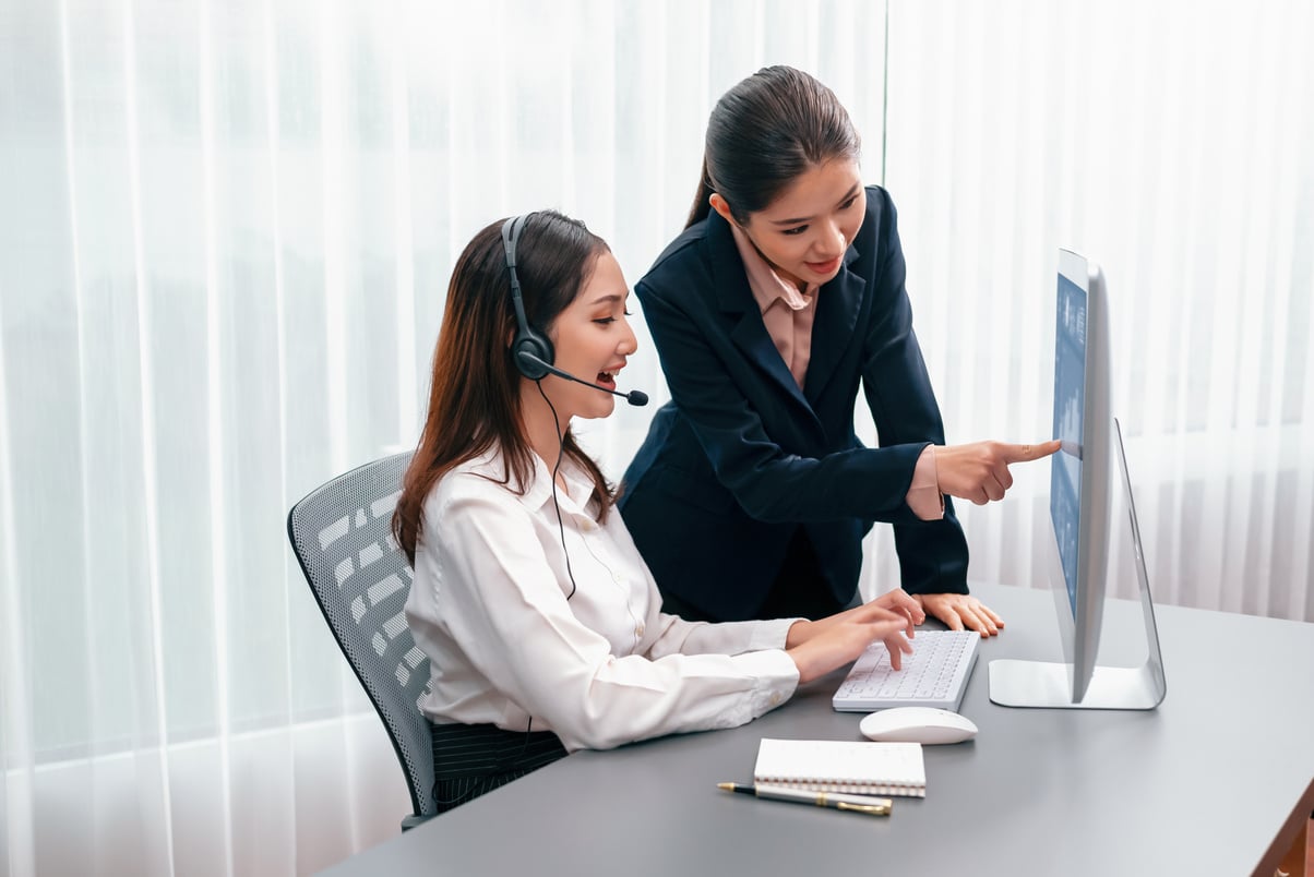 Asian female customer support operator guided by manger Enthusiastic