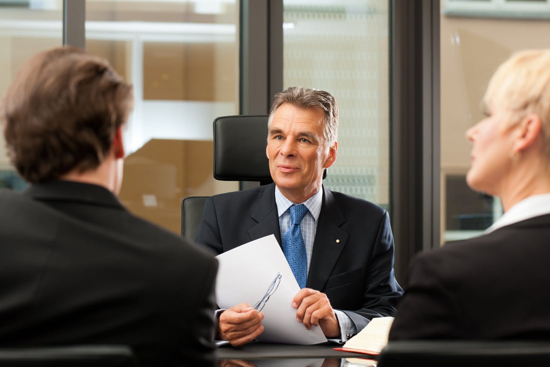 Lawyer or Notary with Clients in His Office